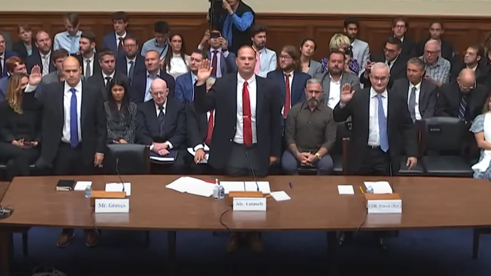 Witnesses with hand raised for oath